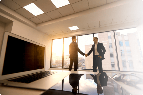Two c Suit Execs shaking hands in a skyrise office (2) (1)